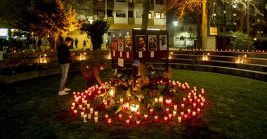 People light candles in front of a kiosk where several were killed in a racist attack one year ago in Hanau, Germany, Feb. 19, 2021. (AP Photo)