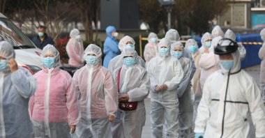 Patients who recovered from COVID-19 wear protective clothing as they line up to be tested again at a hospital in Wuhan, Hubei province, central China, March 14, 2020. (AFP Photo)