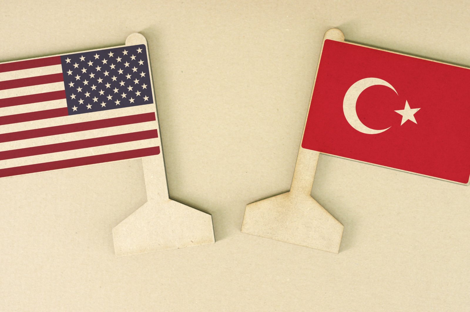 The flags of Turkey and the U.S. made of recycled paper are displayed on a cardboard desk. (Photo by Shutterstock)