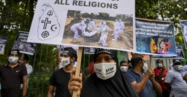 Protesters hold placards during a demonstration against the government policy of forced cremations of Muslims who died of the coronavirus, outside a cemetery in Colombo, Dec. 31, 2020. (AFP Photo)