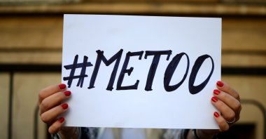 A woman holds up a sign that says “#METOO.” (Shutterstock Photo)