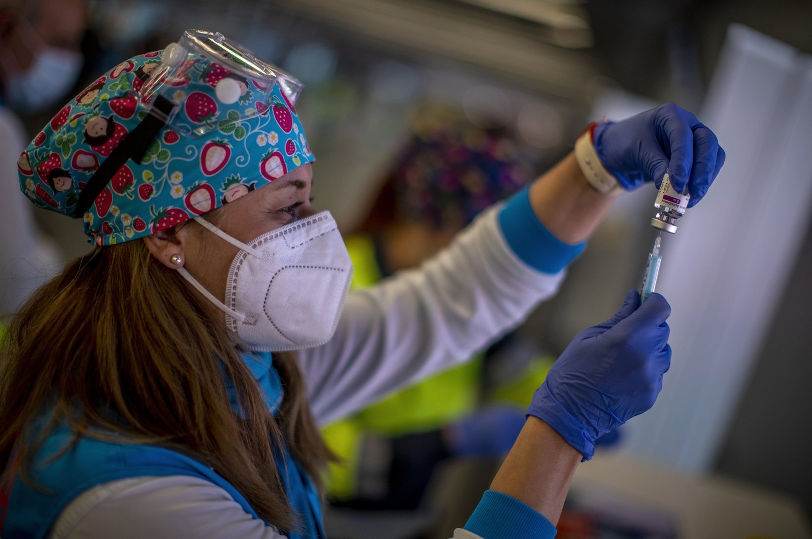 A health worker holds a vial of AstraZeneca vaccine to be administered to emergency services personnel during a mass COVID-19 vaccination campaign at Wanda Metropolitano stadium in Madrid, Spain, Feb. 25, 2021. (AP Photo)