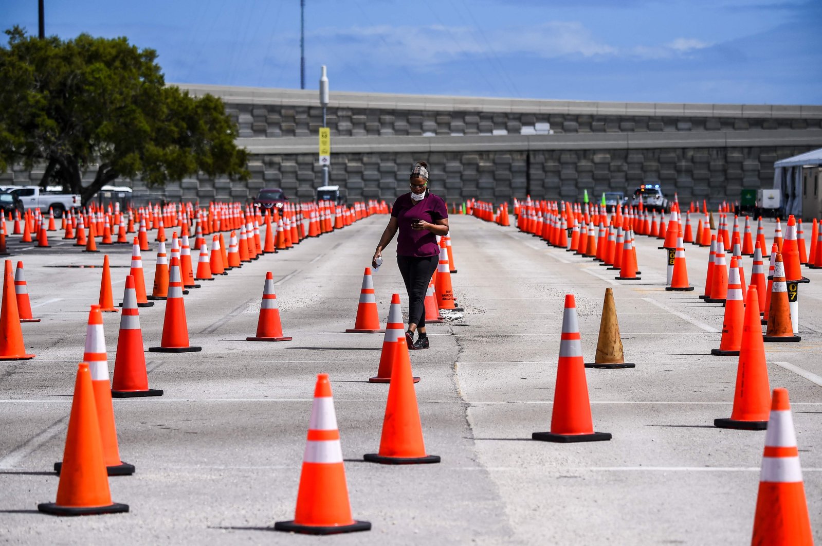 A health care worker walks at a COVID-19 vaccination drive-thru site at Hard Rock Stadium in Miami, Florida, on Feb. 22, 2021. (Photo by CHANDAN KHANNA / AFP)