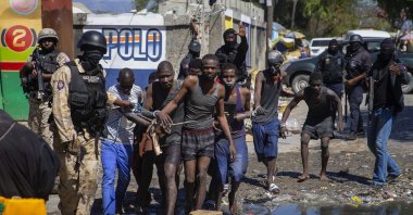 Recaptured inmates are led by police outside the Croix-des-Bouquets Civil Prison after an attempted breakout, in Port-au-Prince, Haiti, Thursday, Feb. 25, 2021. (AP Photo)