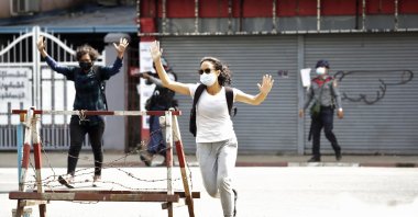 People react as riot police fire tear gas during a protest against the military coup in Yangon, Myanmar, Feb. 27, 2021. (EPA Photo)