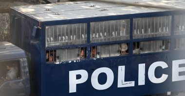 Protesters make the three-finger salute from a police truck in Yangon after a crackdown on demonstrations against the military coup, Yangon, Myanmar, Feb. 27, 2021. (AFP Photo)