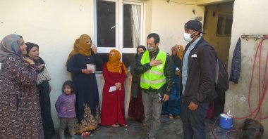 Taha Saleh (R) talks to Syrian refugees during a visit to their home, in Şanlıurfa, southeastern Turkey, Feb. 28, 2021. (İHA PHOTO) 