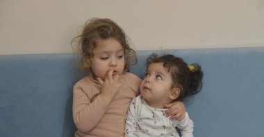 Zehra Elmalıca (L) sits next to her two-year-old sister Öykü, a spinal muscular atrophy (SMA) patient, in the capital Ankara, Turkey, Dec. 11, 2020. (DHA PHOTO)