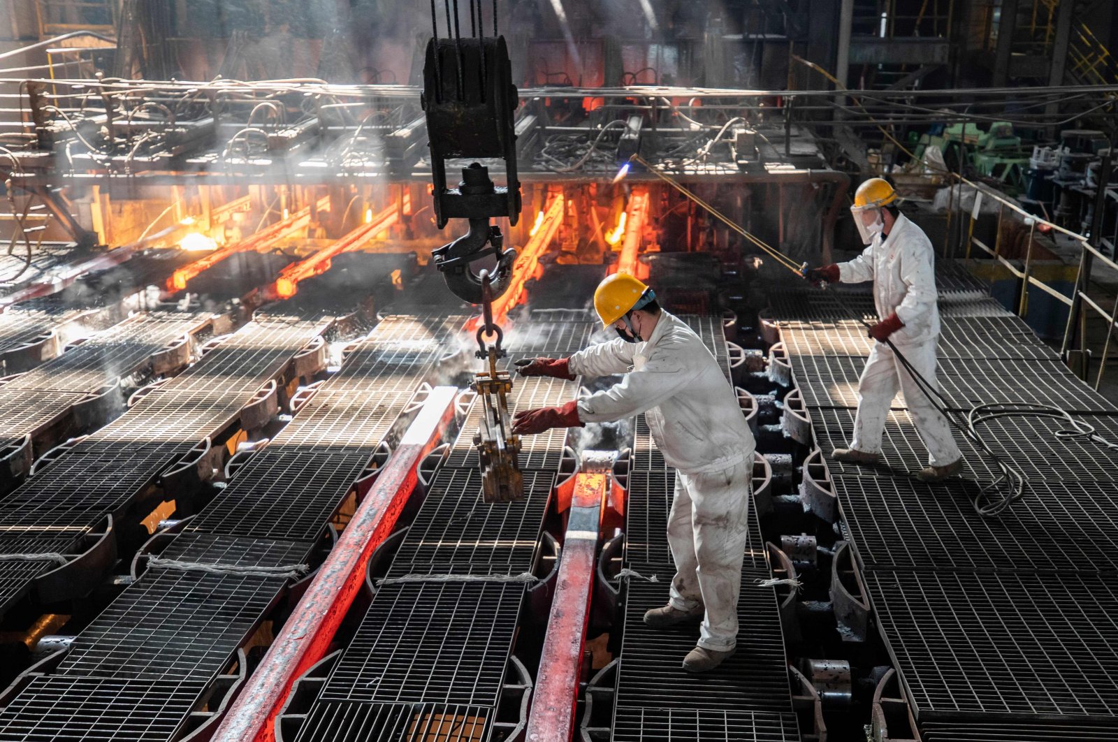 Workers make iron bars in a steel factory in Lianyungang, eastern Jiangsu province, China, Feb. 12, 2021. (AFP Photo)