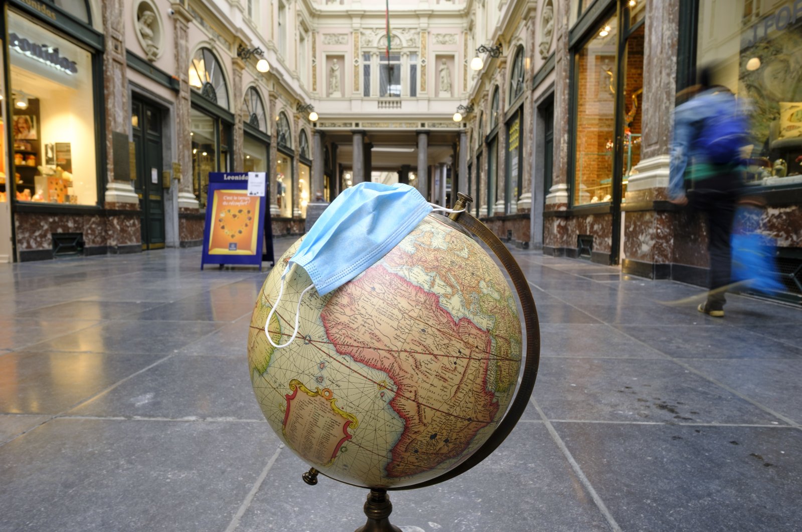 A globe with a surgical mask is seen on the floor of the Galeries Royales Saint-Hubert, Brussels, Belgium, Oct. 28, 2020. (Photo by Getty Images)