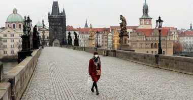 A woman wearing a face mask walks across the empty Charles Bridge in Prague, Czech Republic, March 1, 2021. (Reuters Photo)