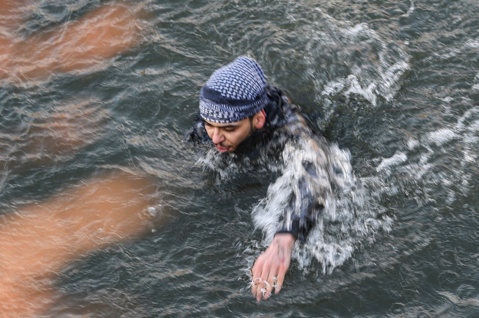 A migrant swims back towards Turkey after trying to enter Greece by crossing the Maritsa river, March 1, 2020. (AFP)