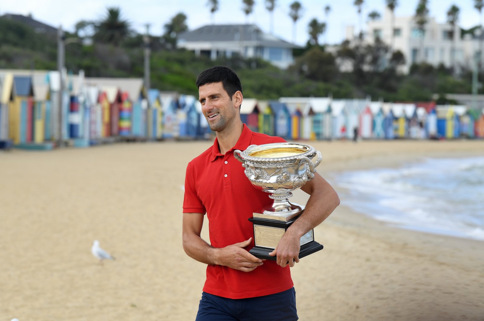 Serbia's Novak Djokovic walks on Brighton Beach with the Australian Open trophy, Melbourne, Australia, Feb. 22, 2021. (EPA Photo)