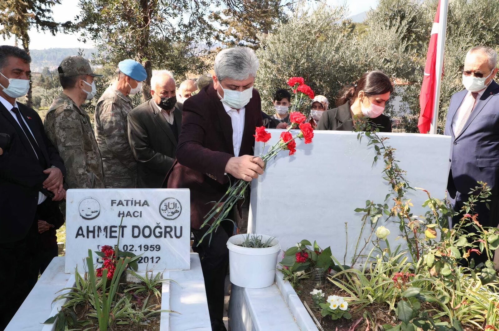 Hatay Governor Rahmi Doğan is seen leaving flowers on the grave of one of the 34 Turkish soldiers that lost their lives during an attack in Syria's Idlib, Hatay, Turkey, Feb. 27, 2021 (AA Photo)