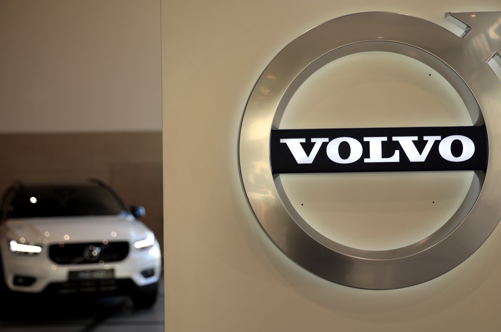 A Volvo car is parked behind the Volvo logo in the lobby of the company's corporate headquarters, in Brussels, Belgium, Feb. 6, 2020. (AP Photo)