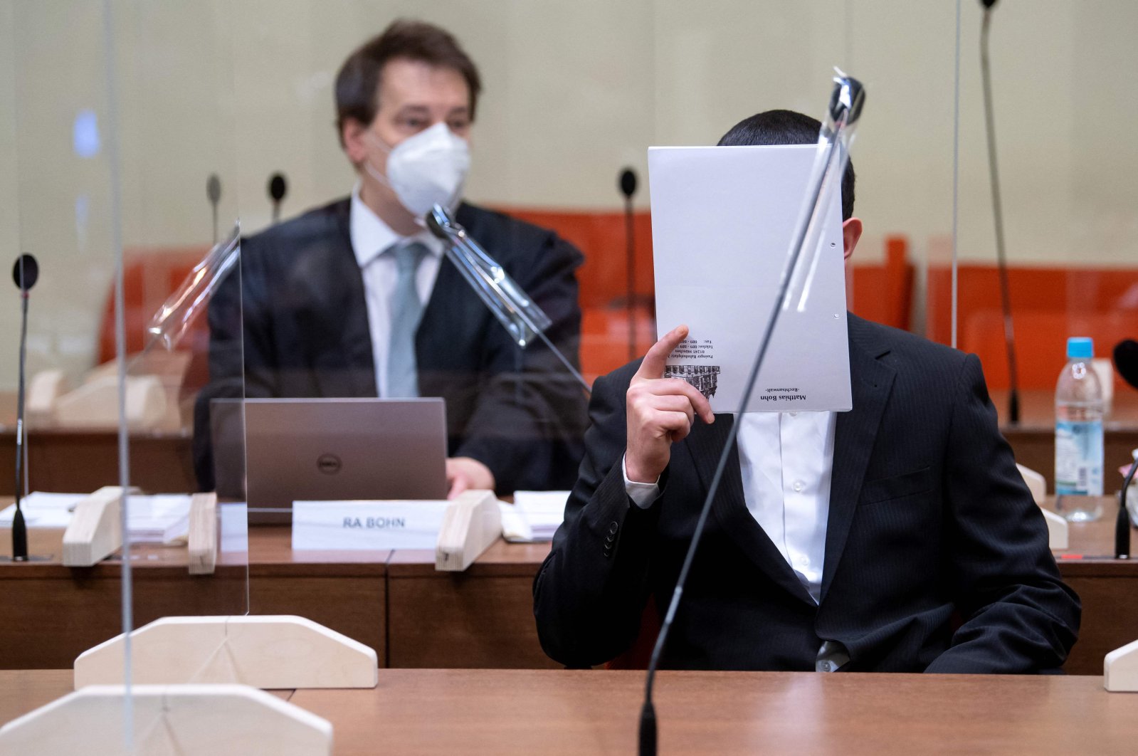 The defendant (R), an alleged member of the terrorist group Daesh, sits next to his lawyer Matthias Bohn as he waits for the opening of his trial in Munich, southern Germany, March 2, 2021. (AFP Photo)