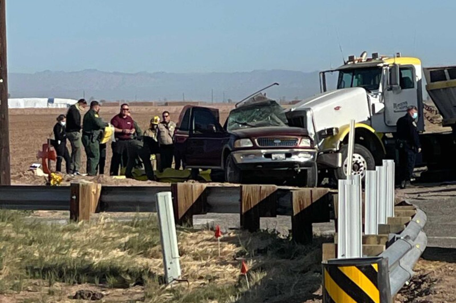 In this image from KYMA law enforcement work at the scene of a deadly crash involving a semitruck and an SUV in Holtville, Calif., on Tuesday, March 2, 2021. (KYMA via AP)