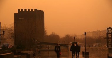 People walk against the backdrop of a sand cloud, in Diyarbakır, southeastern Turkey, Jan. 19, 2018. (AA PHOTO) 