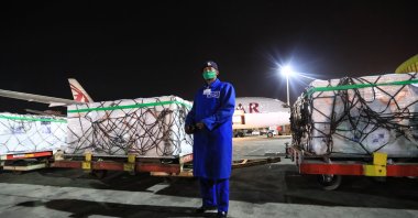 A Kenya police officer (C) stands guard next to some of the first batch of 1.02 million doses of Oxford/AstraZeneca COVID-19 vaccines after their arrival at the Jomo Kenyatta International Airport (JKIA), in Nairobi, Kenya, March 3, 2021. (EPA Photo)