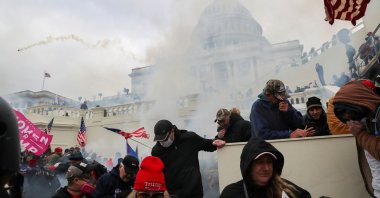 Supporters of U.S. President Donald Trump cover their faces to protect from tear gas during a clash with police officers in front of the U.S. Capitol Building in Washington, U.S., Jan. 6, 2021. (Reuters Photo)