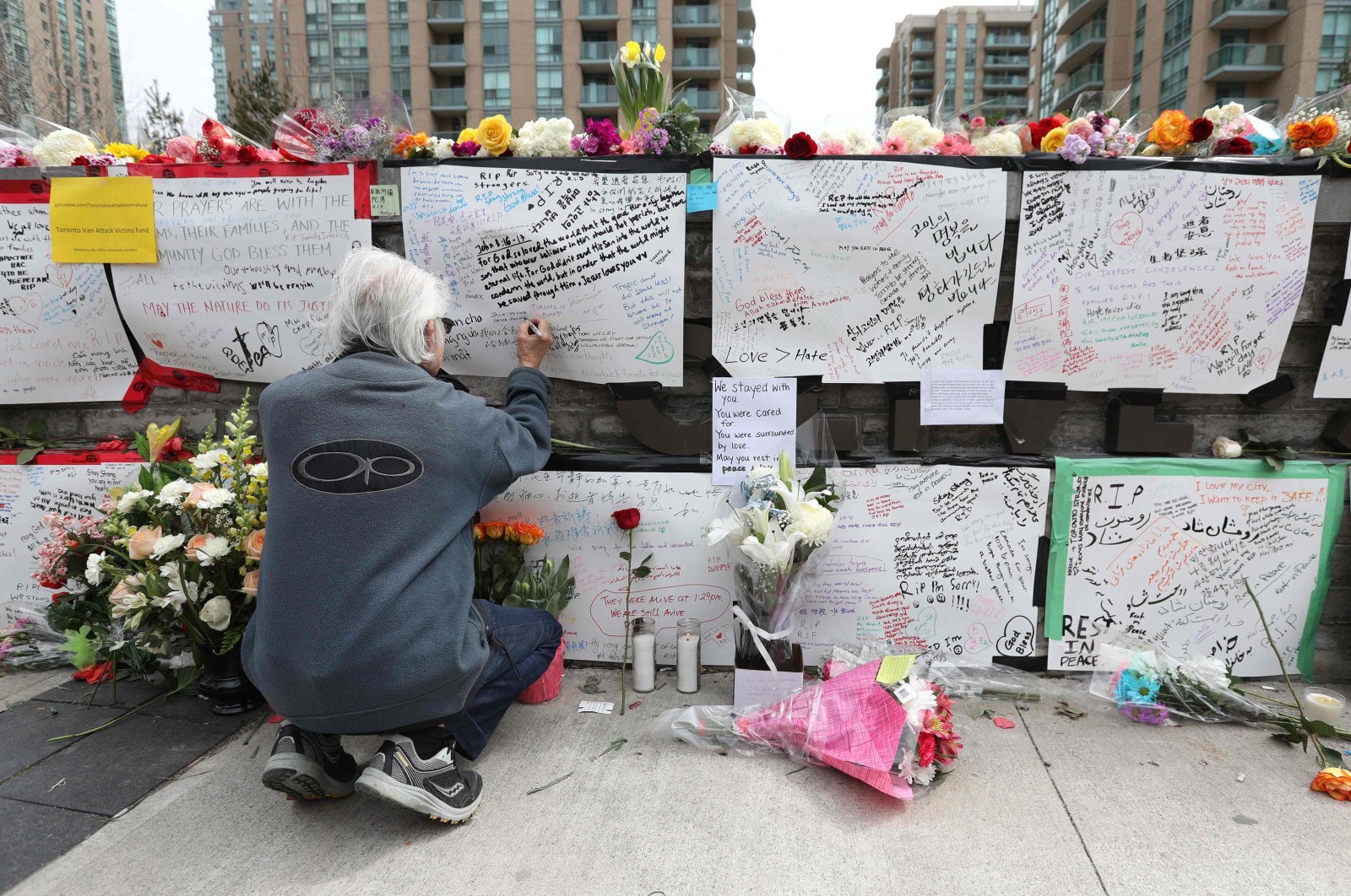 Jack Young leaves a note on April 24, 2018, at a makeshift memorial for victims in the van attack in Toronto, Ontario. (AFP Photo)