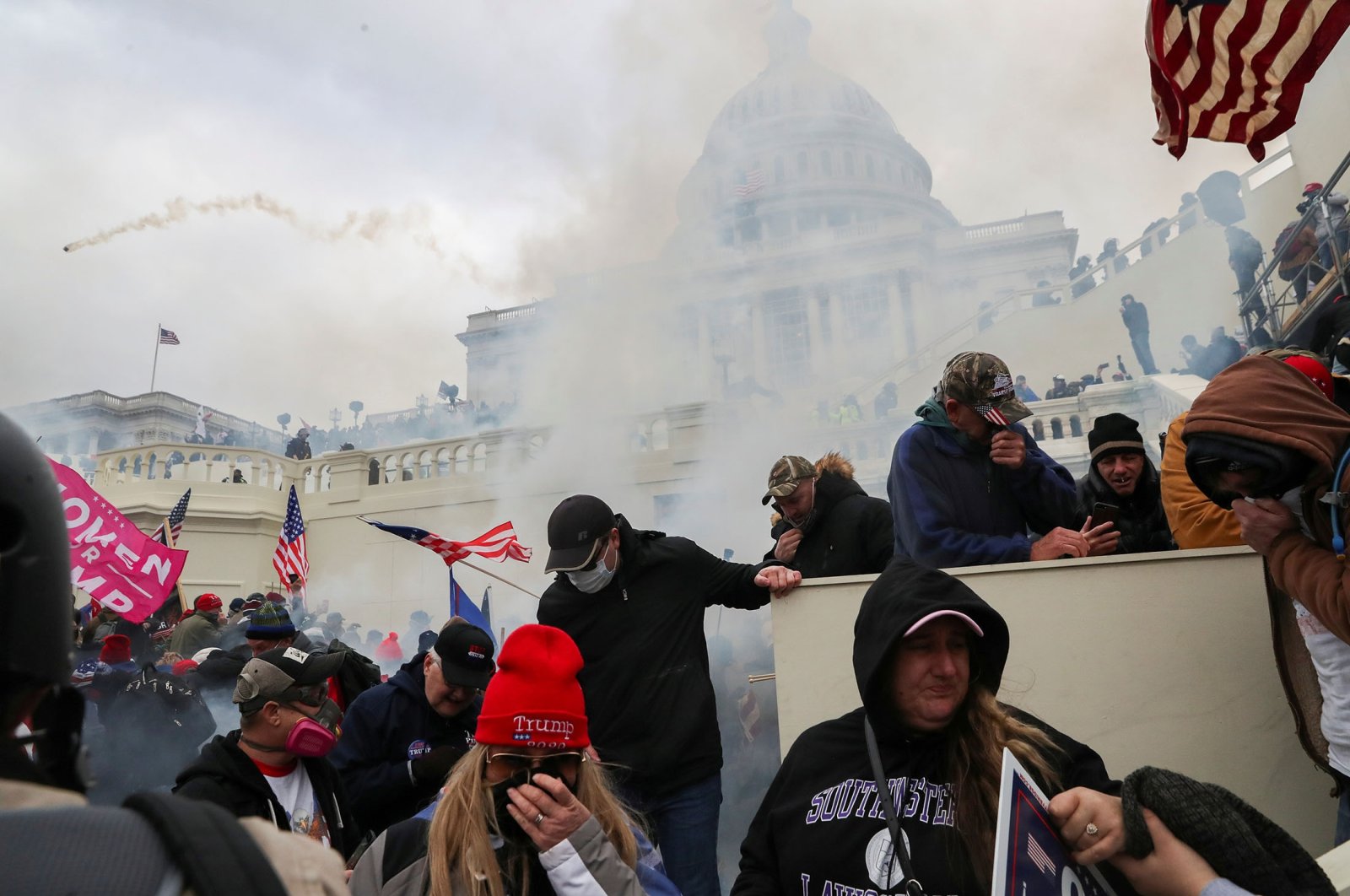 Supporters of U.S. President Donald Trump cover their faces to protect from tear gas during a clash with police officers in front of the U.S. Capitol Building in Washington, U.S., Jan. 6, 2021. (Reuters Photo)