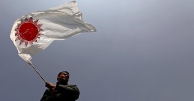 A supporter of a faction of the ruling Nepal Communist Party holds a party flag as he takes part in a rally celebrating the reinstatement of the parliament by Nepal's top court in Kathmandu, Nepal, Feb. 24, 2021. (Reuters Photo)