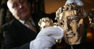 The iconic BAFTA mask awards are polished by a butler at the Savoy Hotel ahead of the British Academy of Film and Television Awards (BAFTA), in London, England, on Feb. 10, 2014. (Getty Images)