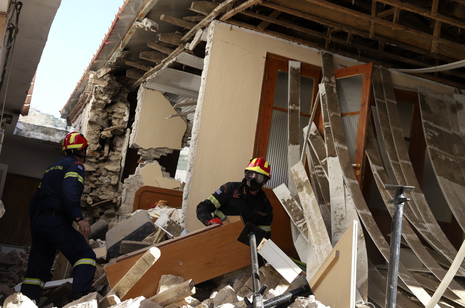 Firefighters search inside a damaged house after an earthquake in Damasi village, central Greece, Thursday, March 4, 2021. (AP Photo)