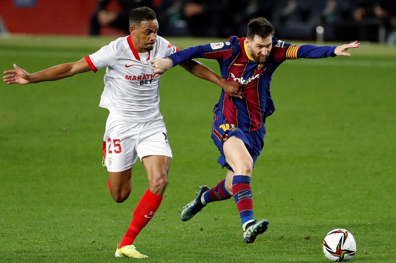 Barcelona's Lionel Messi (R) vies for the ball with Sevilla midfielder Fernando Reges (L) during the second leg Copa Del Rey semifinal at Camp Nou, Barcelona, Spain, March 3, 2021. (EPA Photo)