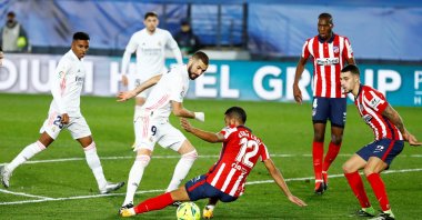 Real Madrid's Karim Benzema (L) in action against Atletico Madrid's Renan Lodi (C) in a La Liga match at Estadio Alfredo Di Stefano, Madrid, Spain, Dec. 12, 2020.