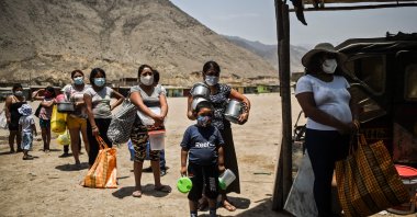 People maintain social distance as they wait to receive food at a soup kitchen in Comas, in the northern outskirts of Lima, Peru, Feb. 3, 2021. (AFP Photo)