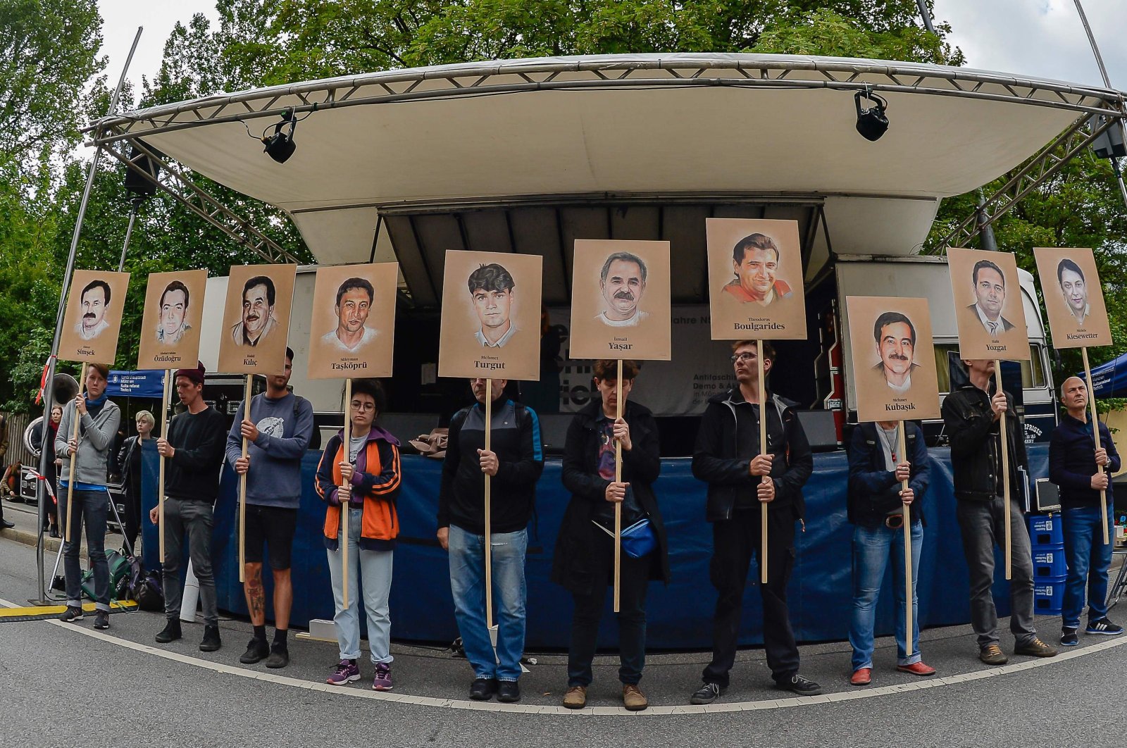 Protestors hold up signs with pictures of the victims of the neo-Nazi cell National Socialist Underground (NSU), in Munich, Germany, July 11, 2018. (AFP)