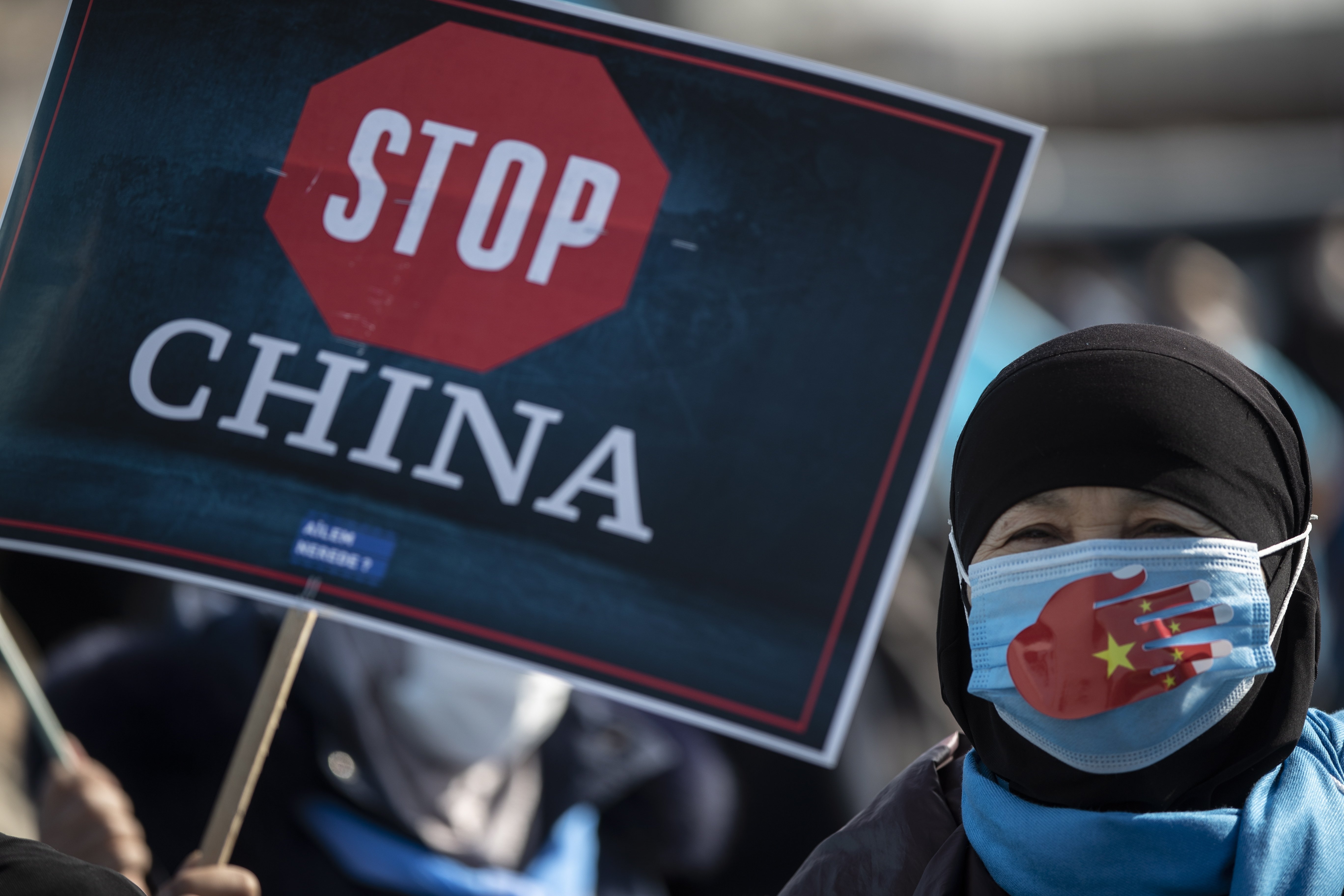 Uyghur protestors who have not heard from their families living in Xinjiang hold placards and the Uyghur flag during a protest against China, in Istanbul, Turkey, Feb. 26, 2021. (EPA Photo)