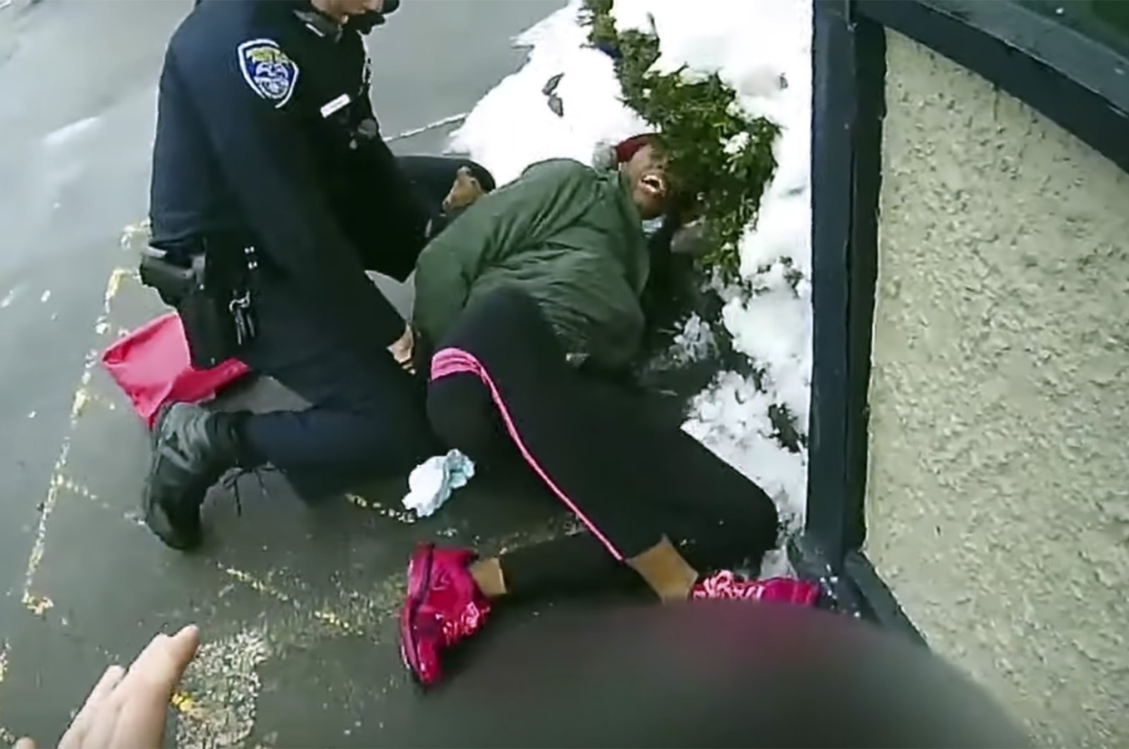 This image taken body camera video released by the Rochester, N.Y., Police Department on Friday, March 5, 2021, shows an officer struggling to subdue a woman suspected of shoplifting who tried to escape with her 3-year-old child in her arms on Feb. 22, 2021.  (Rochester Police Department via AP)