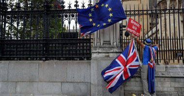 A demonstrator holds a sign that reads "Brexit. Is it worth it?" while waving the European Union and U.K. flag, England, Sept. 11, 2018. (AFP Photo)