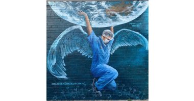 A health care worker in the Atlas pose holding up the earth by Brigitte Dawson and Melissa Turner of Melbourne's Murals, 606 Balcombe Road Blackrock, Melbourne, Victoria, Australia. (Courtesy of YEE)