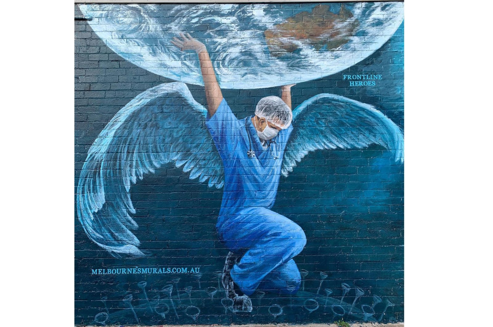 A health care worker in the Atlas pose holding up the earth by Brigitte Dawson and Melissa Turner of Melbourne's Murals, 606 Balcombe Road Blackrock, Melbourne, Victoria, Australia. (Courtesy of YEE)