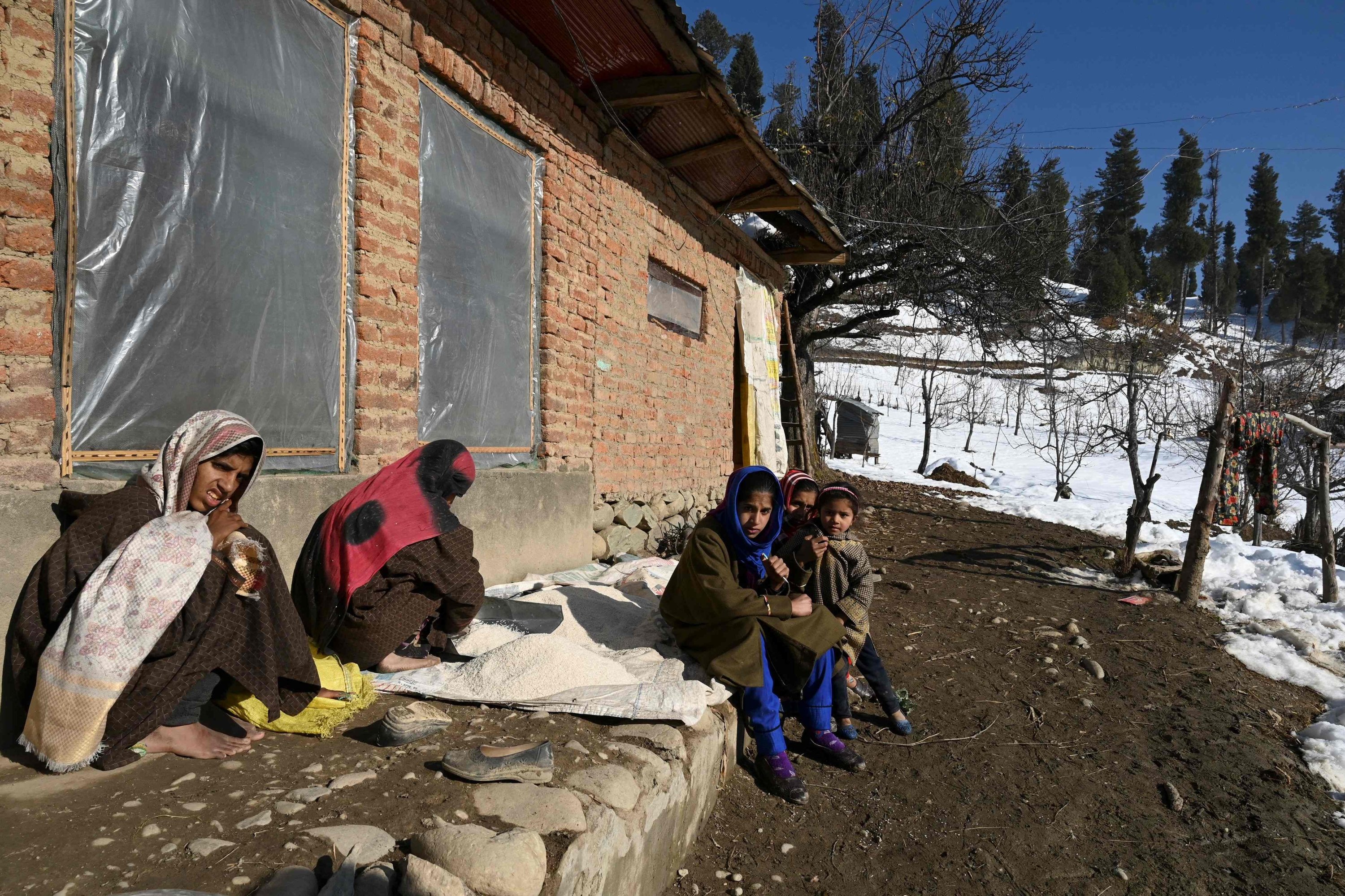 Biya Bano (2nd L) sits with her children outside their mud-brick home in the Nagbal area in Indian-administered Kashmir, Dec. 15, 2020. (AFP Photo)