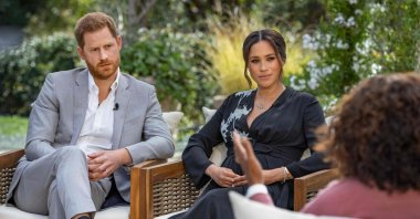 Britain's Prince Harry (L) and his wife Meghan (C), Duchess of Sussex, sit in conversation with U.S. television host Oprah Winfrey, U.S., March 7, 2021. (AFP)