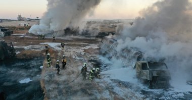 In this photo provided by the Syrian Civil Defense group known as the White Helmets, civil defense workers extinguish burning oil tanker trucks after a suspected missile strike around the towns of Jarablus and al-Bab, near the border with Turkey, in western Aleppo province, Syria, March 6, 2021. (AP Photo)