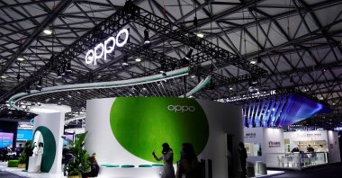 People walk past a booth of smartphone maker Oppo at the Mobile World Congress (MWC) in Shanghai, China, Feb. 23, 2021. (Reuters Photo)