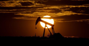 The sun sets behind an idle pump jack near Karnes City, U.S, April 8, 2020. (AP Photo)
