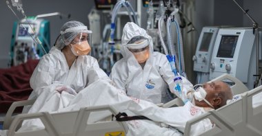 Two women health care workers attend a COVID-19 patient at a hospital, in Izmir, western Turkey, Mar. 8, 2021. (AA PHOTO) 