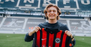 Turkish forward Ali Akman poses with the jersey of his club Eintracht Frankfurt, Frankfurt, Germany, March 7, 2021.