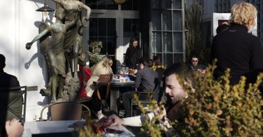 People sit outside a coffee shop as cafes, restaurants and other eateries reopened in some provinces across the country, in the capital Ankara, Turkey, March 3, 2021. (AP Photo)