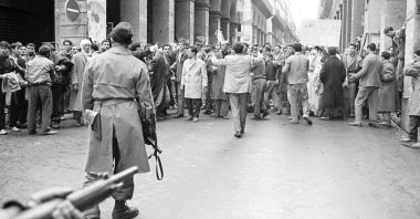 Armed French soldiers (foreground) face a shouting mob of Algerians at an entrance to the Casbah native quarter in Algiers, Dec. 14, 1960. (AP Photo)