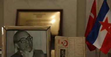 A portrait and the passport of the slain diplomat Galip Balkar are seen next to the flags of Turkey and Yugoslavia in this photo taken at the Turkish Embassy in Serbia's Belgrade on March 9, 2017 (AA File Photo)