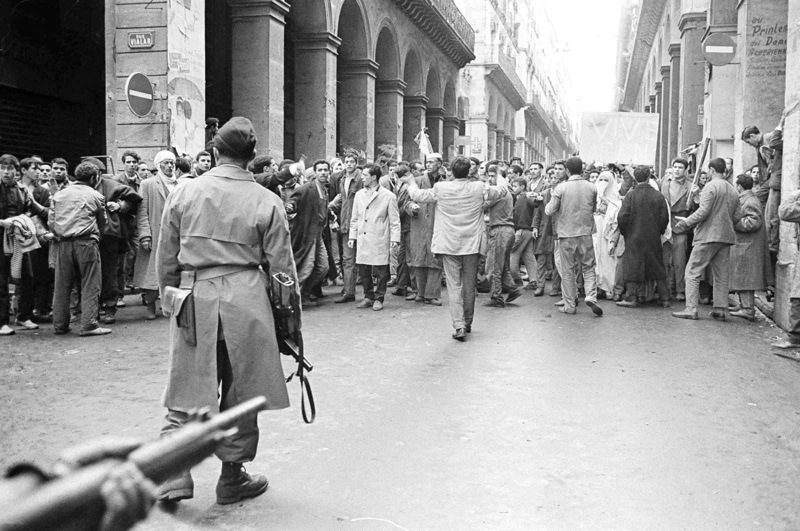 Armed French soldiers (foreground) face a shouting mob of Algerians at an entrance to the Casbah native quarter in Algiers, Dec. 14, 1960. (AP Photo)
