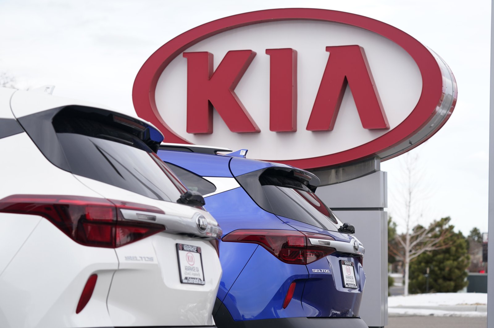 The company sign stands over a row of unsold 2021 Seltos models at a Kia dealership, in Centennial, Colorado, U.S., Dec. 20, 2020. (AP Photo)